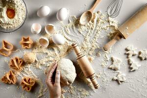 Baking preparation. Raw dough and cutters for the holiday cookies on a white table. Top view. photo