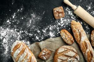 Mixed breads on black table. Top view with copy space. photo