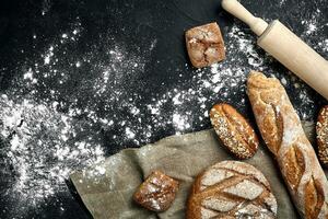 Mixed breads on black table. Top view with copy space. photo