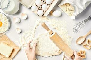 Baking preparation. Raw dough and cutters for the holiday cookies on a white table. Top view. photo