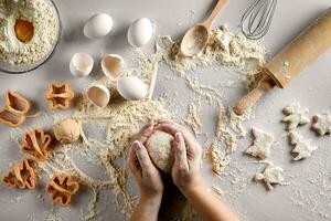 Baking preparation. Raw dough and cutters for the holiday cookies on a white table. Top view. photo