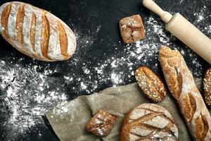 Mixed breads on black table. Top view with copy space. photo