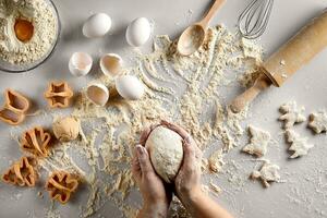 Baking preparation. Raw dough and cutters for the holiday cookies on a white table. Top view. photo