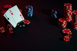 Casino chips and cards on black table surface. Gambling, fortune, game and entertainment concept - close up photo