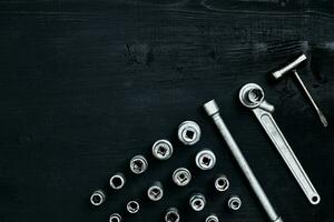 Tools for car repair in Workshop. Car repair equipment on black wooden background in car repair shop photo