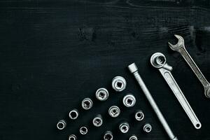 Tools for car repair in Workshop. Car repair equipment on black wooden background in car repair shop photo