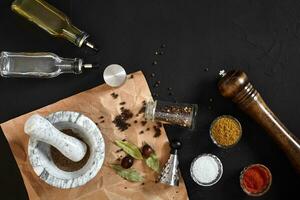 Various spices and mortar on black background with copy space photo