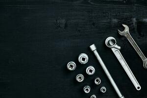 Tools for car repair in Workshop. Car repair equipment on black wooden background in car repair shop photo