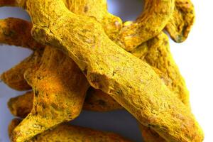 Dry Turmeric roots or barks isolated on white background. Close-up photo