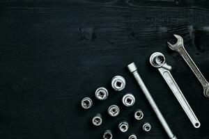 Tools for car repair in Workshop. Car repair equipment on black wooden background in car repair shop photo
