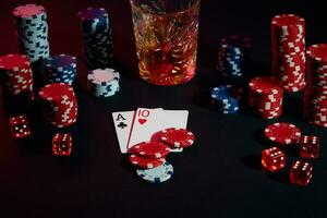 Cards of poker player. On the table are chips and a glass of cocktail with whiskey. Combination of cards photo