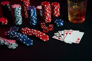 Cards of poker player. On the table are chips and a glass of cocktail with whiskey. Combination of cards photo