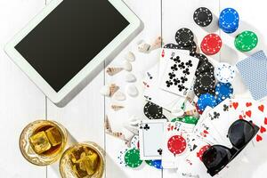 Gambling. Poker chips, cards and the dice nearby tablet on wooden table. Top view. Copyspace. Poker photo