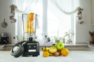 Blender and fruits on kitchen space photo