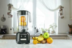 Blender and fruits on kitchen space photo