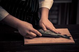 Chef cutting the fish on a board photo