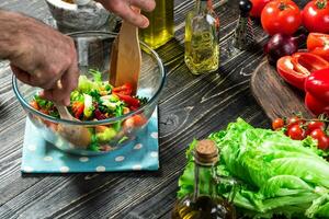 Man preparing salad with fresh vegetables on a wooden table. Cooking tasty and healthy food. Close-up photo