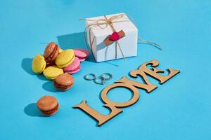 Macaroons and gift box on a blue background with the words I lov photo