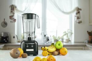 Blender and fruits on kitchen space photo