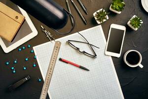 Top view of the builder's workplace, ruler, paper for drawings, compasses, glasses, tablet photo