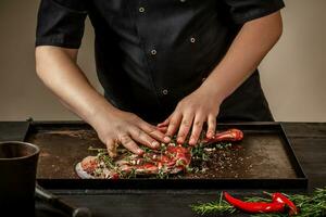 masculino cocinero frotamiento crudo Cordero vástagos con verduras y especias en Roca bandeja en de madera mesa. cocinero Cocinando apetitoso caña de cordero. foto