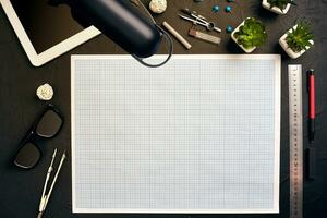 Top view of the builder's workplace, ruler, paper for drawings, compasses, glasses, tablet photo
