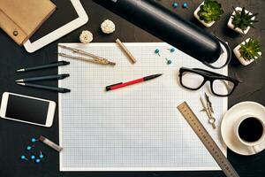 Engineer's desk in office with various gadgets and documents photo