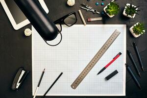 Top view of the builder's workplace, ruler, paper for drawings, compasses, glasses, tablet photo