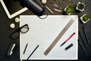 Top view of the builder's workplace, ruler, paper for drawings, compasses, glasses, tablet photo