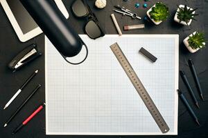 Top view of the builder's workplace, ruler, paper for drawings, compasses, glasses, tablet photo