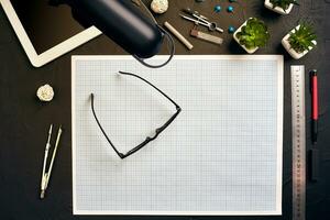 Top view of the builder's workplace, ruler, paper for drawings, compasses, glasses, tablet photo