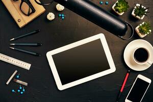 Engineer's desk in office with various gadgets and documents photo