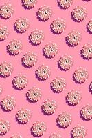 Food design with tasty pink glazed donut on coral pink pastel background top view pattern photo