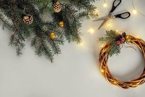 Christmas background with decorations, garland and pine cones. Creating wreath made of christmas tree branches on white background. photo