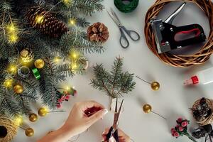 Christmas background with decorations, garland and pine cones. Creating wreath made of christmas tree branches on white background. photo