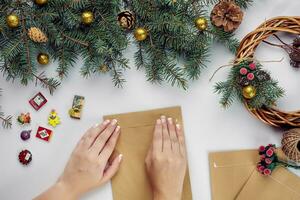 Female hands hold Merry Christmas card and envelope. Christmas decoration background. Flat lay, top view. photo