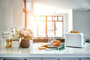 Hot morning in a white kitchen with fresh toast. Sun flare photo