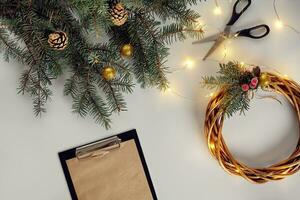 Christmas background with decorations, garland and pine cones. Creating wreath made of christmas tree branches on white background. photo