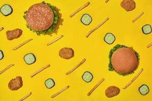 Most popular fast food meal. Chicken nuggets, burgers and french fries on yellow background top view photo