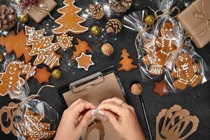 Christmas cookie tree made with star cookie cutter gingerbread new year pastry decorated with rope bow and form for cutting out cookies on black table. photo