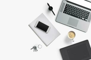 Office desk table with laptop computer, smartphone with black screen over a notebook and cup of coffee. Top view. photo