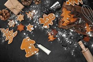 Woman decorating gingerbread Christmas cookies with icing sugar. Christmas preparations concept. Top view with copy space. photo