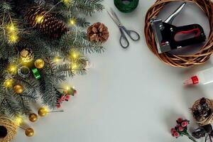 Christmas background with decorations, garland and pine cones. Creating wreath made of christmas tree branches on white background. photo