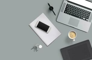 Office desk table with laptop computer, smartphone with black screen over a notebook and cup of coffee. Top view. photo