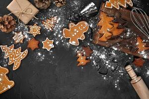 Navidad hecho en casa pan de jengibre galletas, especias y corte tablero en oscuro antecedentes con Copiar espacio para texto parte superior vista. nuevo año y Navidad tarjeta postal foto