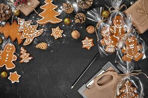 un Navidad pan de jengibre Galleta en el forma de un Navidad árbol en un celofán embalaje en el antecedentes de un oscuro mesa. Navidad regalo concepto. foto