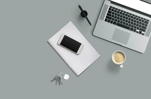 Office desk table with laptop computer, smartphone with black screen over a notebook and cup of coffee. Top view. photo