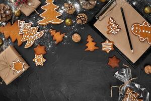 un Navidad pan de jengibre Galleta en el forma de un Navidad árbol en un celofán embalaje en el antecedentes de un oscuro mesa. Navidad regalo concepto. foto