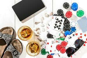 Poker. Set to playing poker with cards and chips on white wooden table, top view photo