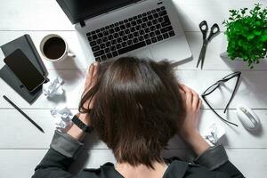 Overhead view of businesswoman working at computer in office photo